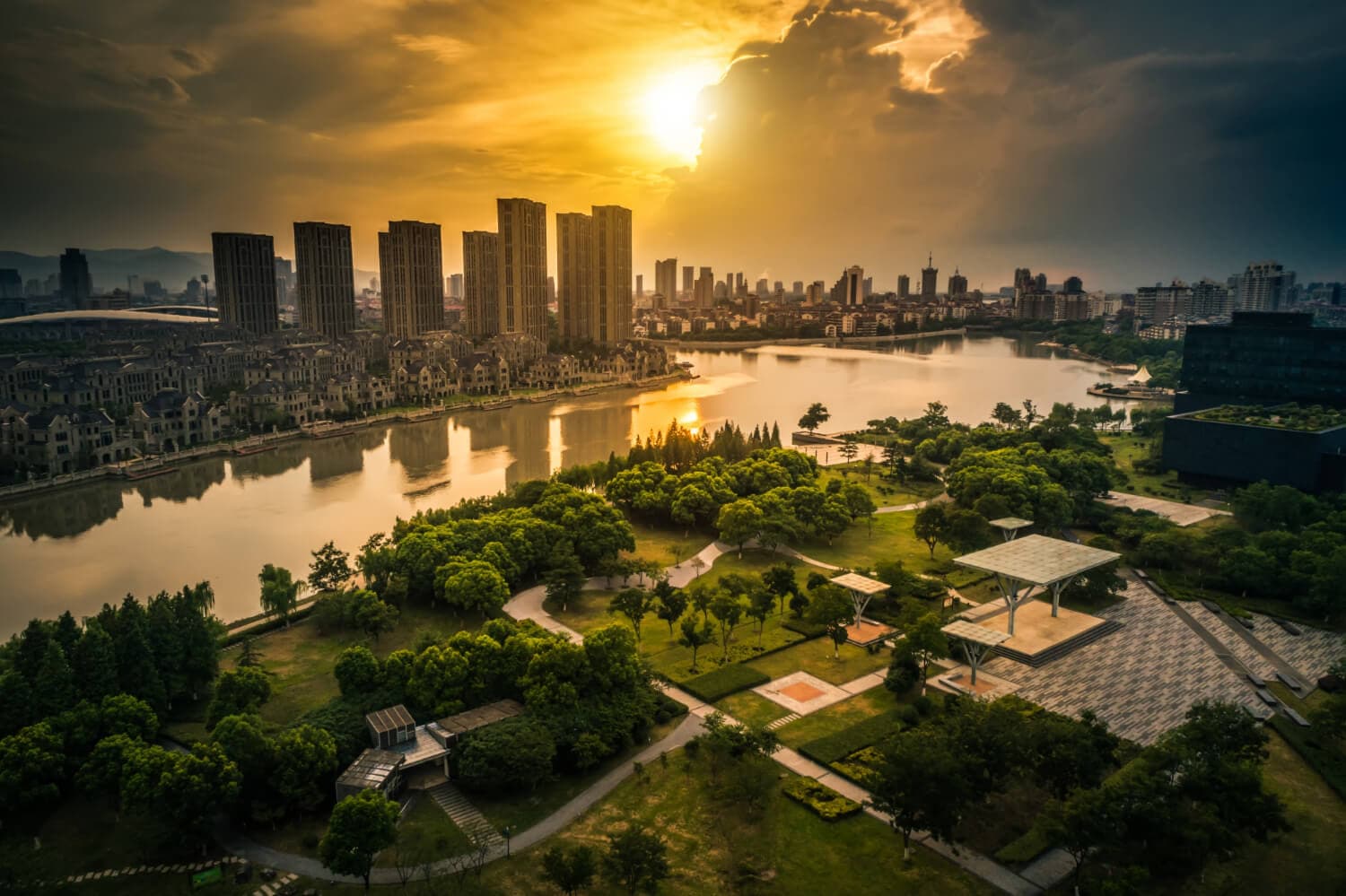 A city skyline beside a river at sunset